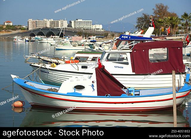 Traditional fishing boats inside the harbour of ancient Kydonies todays Ayvalik town with the Cunda bridge at the background, Balikesir, Aegean Region, Turkey