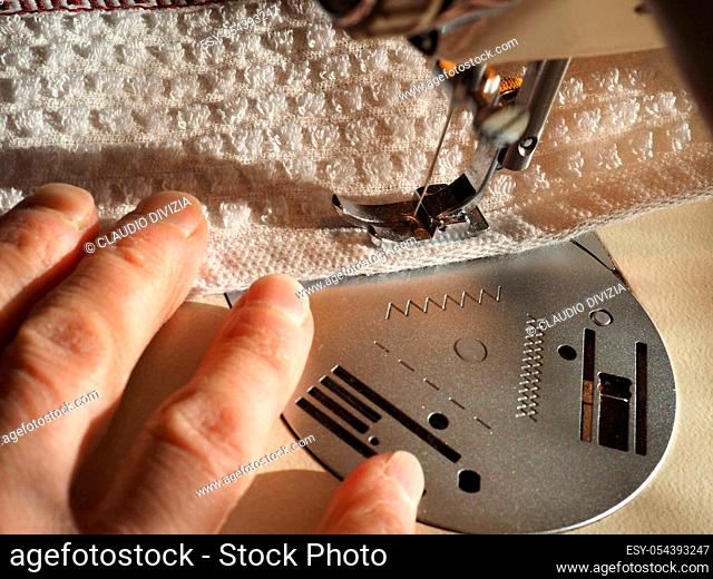 sewing machine to sew pieces of cloth together, motion blur showing needle movement