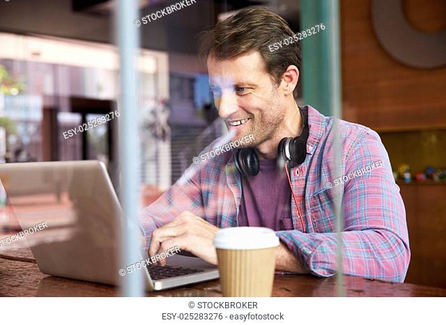 Businessman Working On Laptop In Coffee Shop