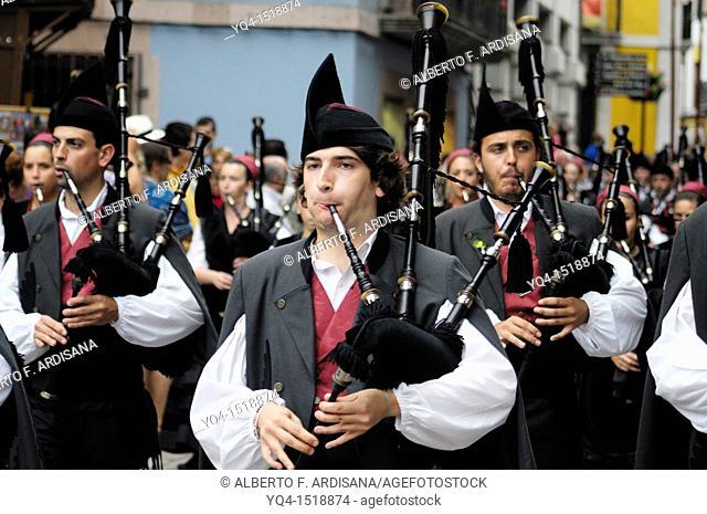 Parade of pipe bands through the streets of Llanes during the festival of San Roque, Llanes, Asturias, Spain