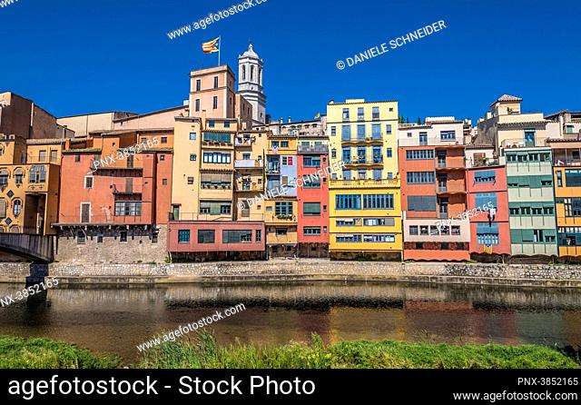 Spain Catalonia, Girona, Onyar river, coloured facades of the old town, flag and bell tower of the Girona cathedral