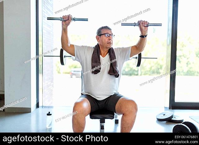 Active and healthy senior exercising in a gym