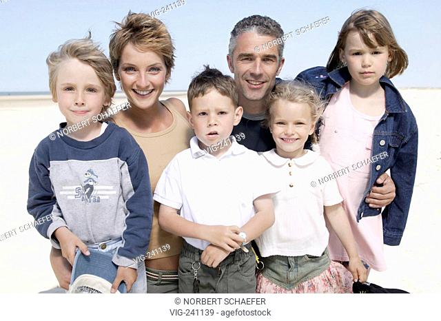portrait, family, couple middle of 30 with their 4 children in the age of 3 - 10 years wearing leisure wear at the beach  - GERMANY, 03/11/2003