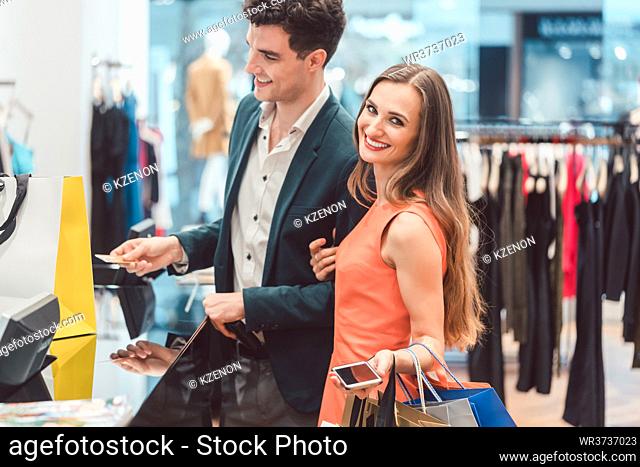 Man buying his woman fashion items in store with credit card