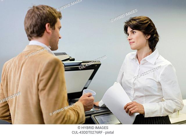 Business people talking at copier