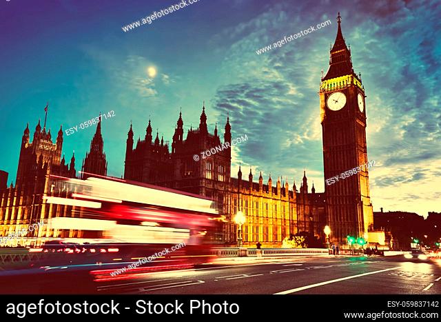 Red bus in motion, Big Ben and Westminster Palace in London, the UK. at night. View from Westminster Bridge. Moon shining, vintage, retro