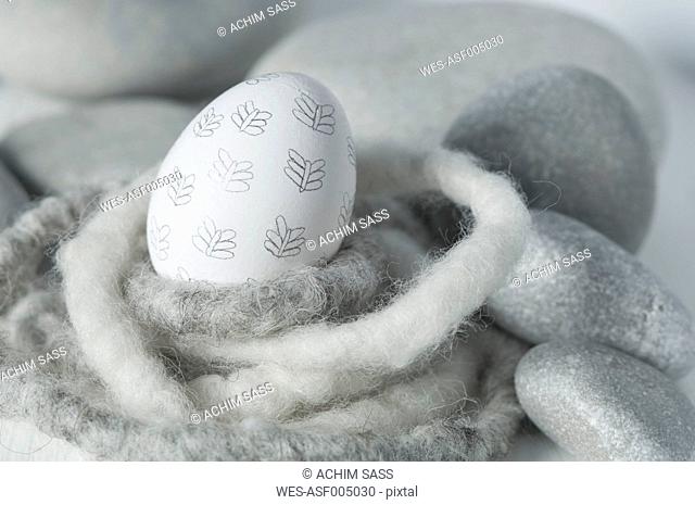 Easter egg in nest with pebbles, close up