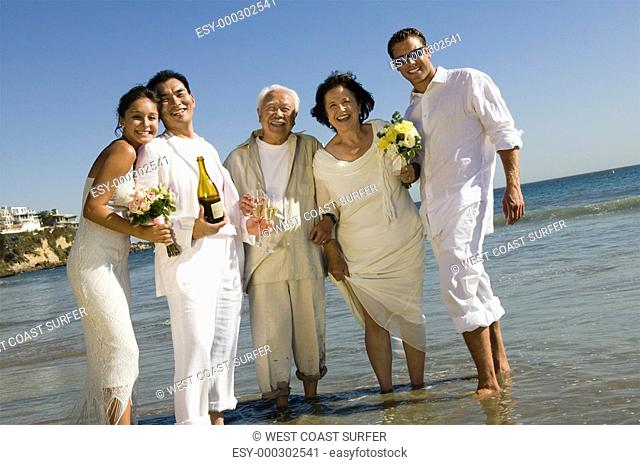 Two newly wed couples and a best man at ocean portrait
