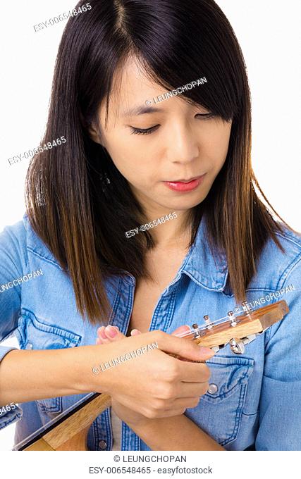 Asian woman tunning ukelele