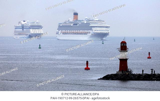 12 July 2019, Mecklenburg-Western Pomerania, Rostock: On the Baltic Sea off Warnemünde the cruise ships ""Aidamar"" (l-r) and ""Costa Favolosa"" set course for...