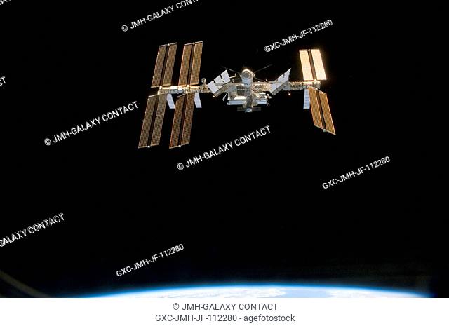 Backdropped by the blackness of space, the International Space Station is seen from Space Shuttle Discovery as the two spacecraft begin their relative...