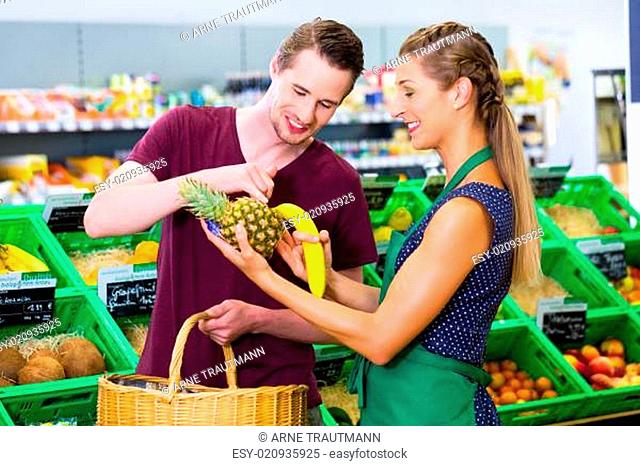 Mann beim Einkaufen im Biomarkt mit Verkäuferin