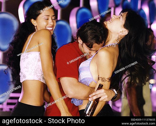 Man dancing with two women at nightclub