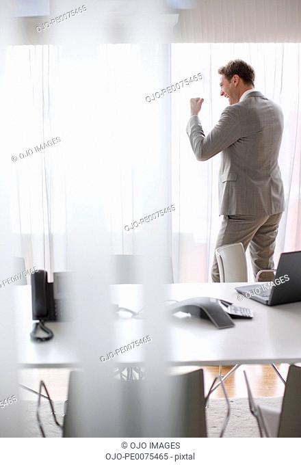 Businessman cheering in conference room