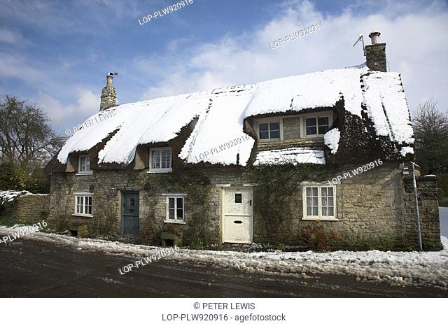 England, Dorset, Corfe Castle, Thatched Cottage in the village of Corfe Castle after a heavy snowfall