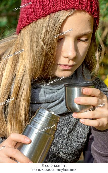 Girl drinks tea from a thermos