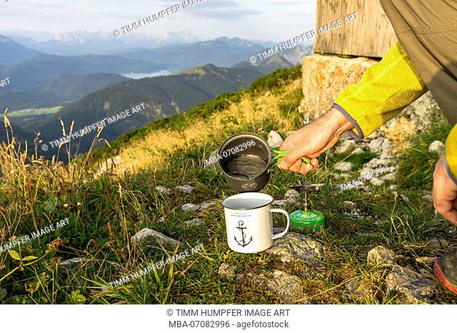 Germany, Bavaria, Bavarian foothills, Lenggries, hiker cooks coffee on the Benediktenwand (mountain)