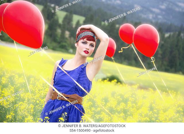 A beautiful young caucasian female in a canola field with balloons near Spokane, Washington, USA