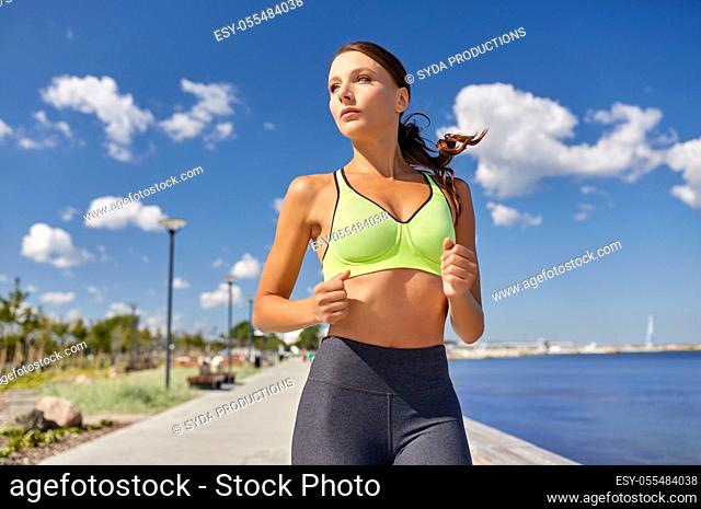 young woman running along sea promenade