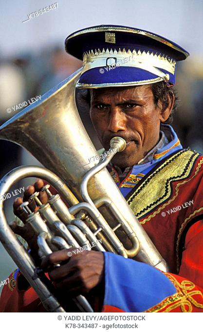 Indian man playing trombone. India