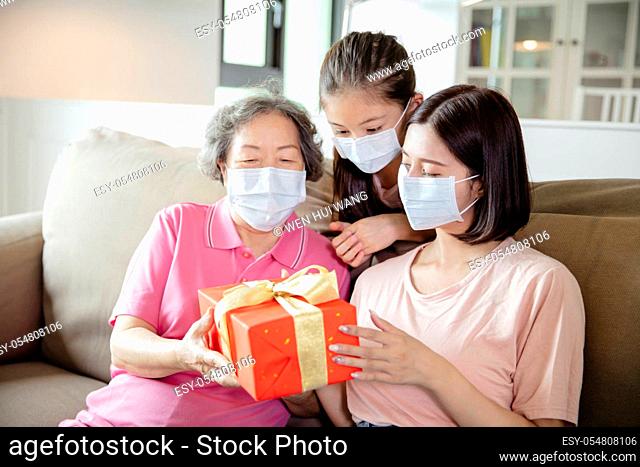 mother and grandmother with daughter wearing face mask to celebrating mothers day