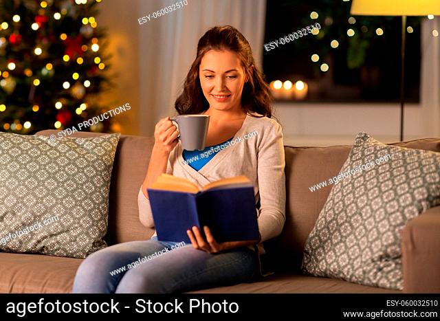 young woman reading book at home on christmas