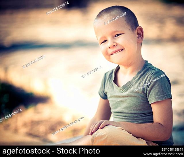 Outdoor portrait of cute little smiling boy