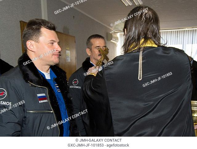 Expedition 34 Flight Engineer Chris Hadfield of the Canadian Space Agency, right, receives the traditional blessing from a Russian Orthodox priest at the...
