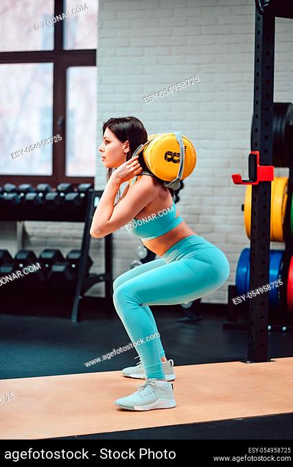 Young adult girl doing strength exercises in the gym, healthy life