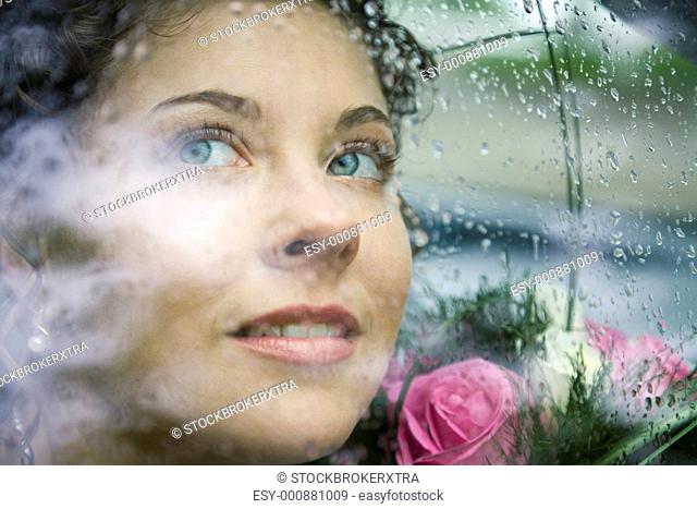 Photo of pretty face of bride through window of car