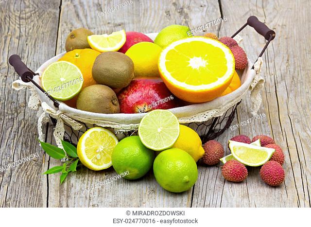 fresh fruits in a basket on wooden background