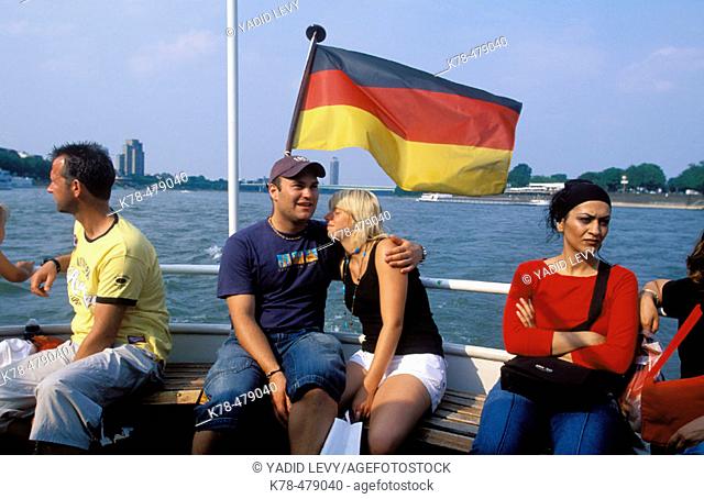 Germany, North Rhine Westphalia, Cologne. People on a boat crossing the Rhine river