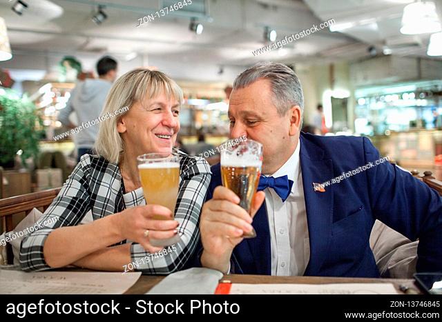 An elderly couple enjoying their beer in a cafe