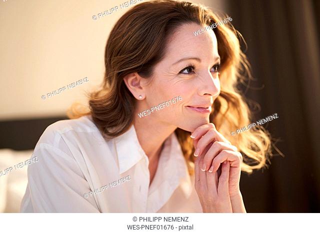 Portrait of smiling woman in bedroom at home