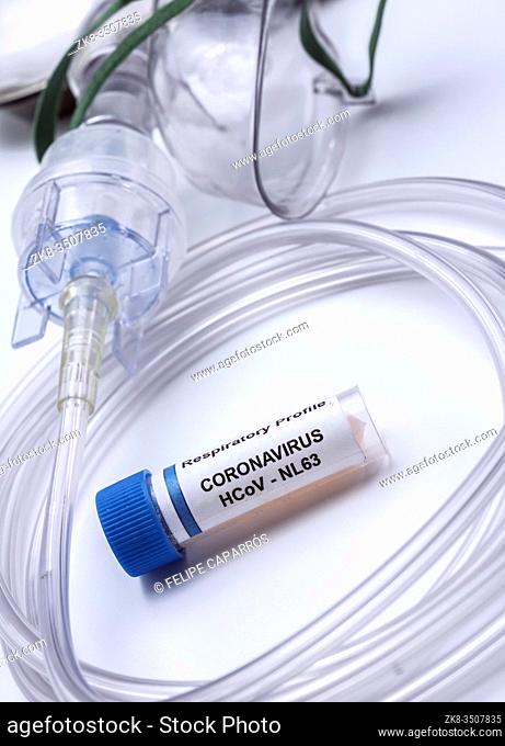 Vial with Sars-cov-2 coronavirus sample next to an oxygen mask in a hospital, conceptual image