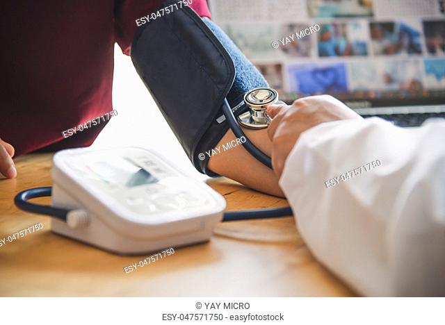 doctor measuring blood pressure from her patient