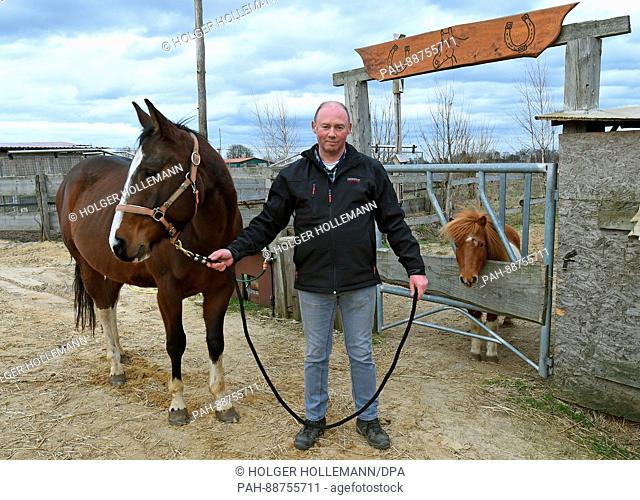 Farmer Andreas Strahlmann stands next to his gelding Santos at his farm in Wettmar, Germany, 28 February 2017. 60 horses live in the horse boxes he rents out to...