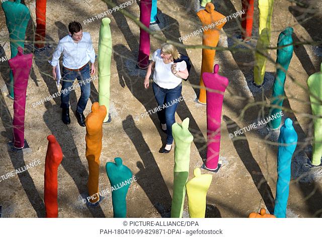 10 April 2018, Germany, Bad Iburg: Visitors walk through a group of sculptures in the run-up to the National Garden Show