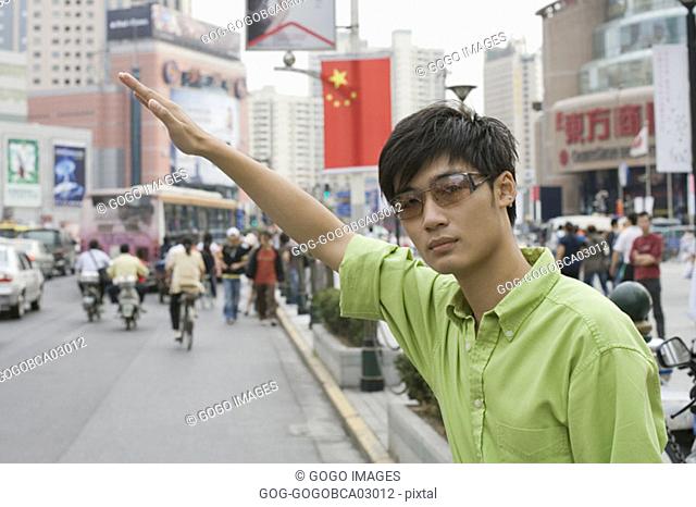 Young man hailing a taxi