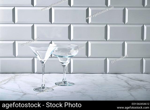 Glass empty glasses for martini, champagne, alcoholic and non-alcoholic cocktails such as Margarita or Manhattan on marble table