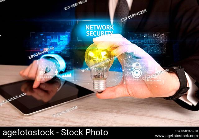 Businessman holding lightbulb with NETWORK SECURITY inscription, online security idea concept