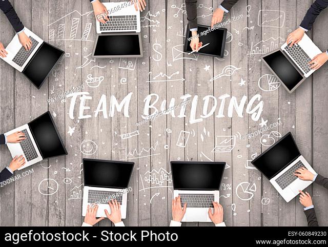 Group of business people working in office with TEAM BUILDING inscription, coworking concept