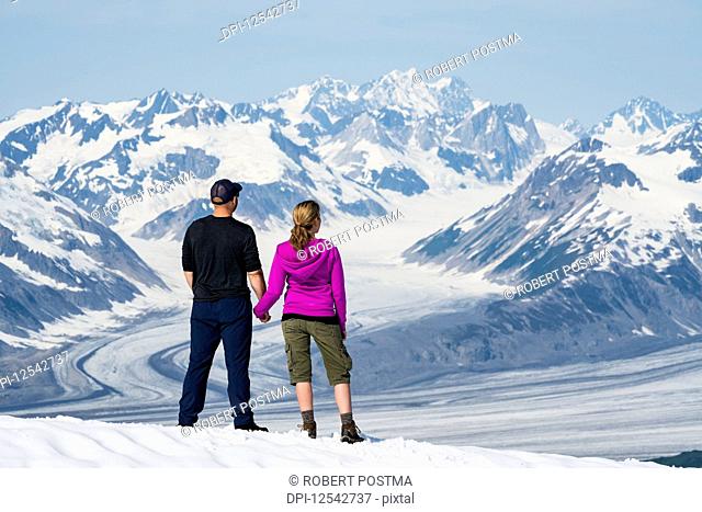 A couple enjoy the sights and scenery of Kluane National Park and Reserve on a bright sunny day; Haines Junction, Yukon, Canada