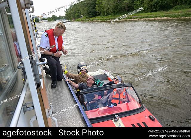 27 May 2022, Saxony-Anhalt, Magdeburg: Inspector Florian Schmidt (l) checks the papers of boatman Jens Teichmann, who is traveling with his family on the Elbe