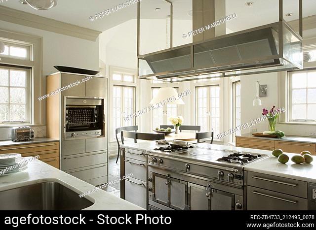 Extractor fan above central island unit in modern kitchen