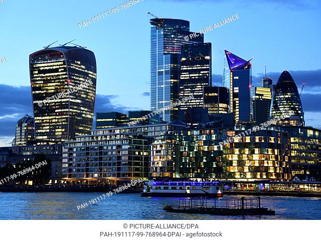 05 September 2019, Great Britain, London: View during the blue hour over the Thames to the skyscrapers in the London financial district