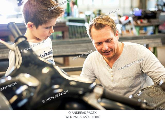 Father and son maintaining vintage moped
