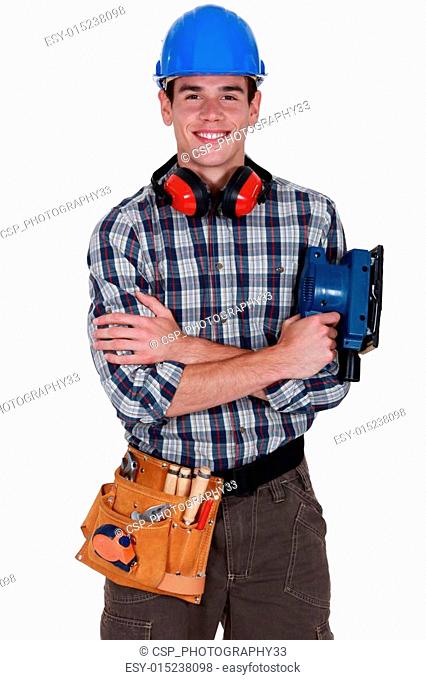 Young tradesman holding a sander