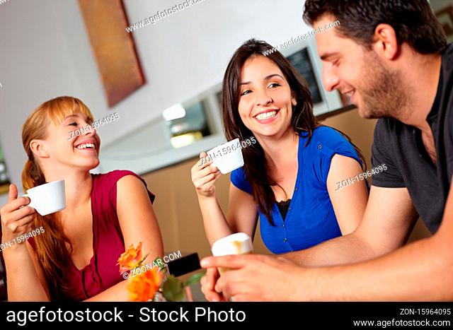Drei lachende Freunde sitzen im Café