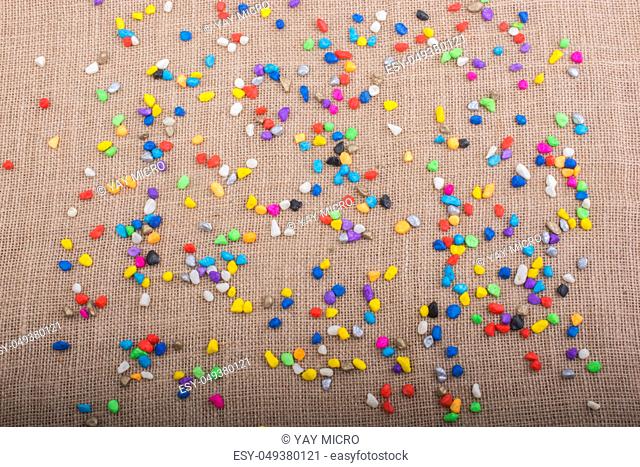 Colorful pebbles spread on a canvas background